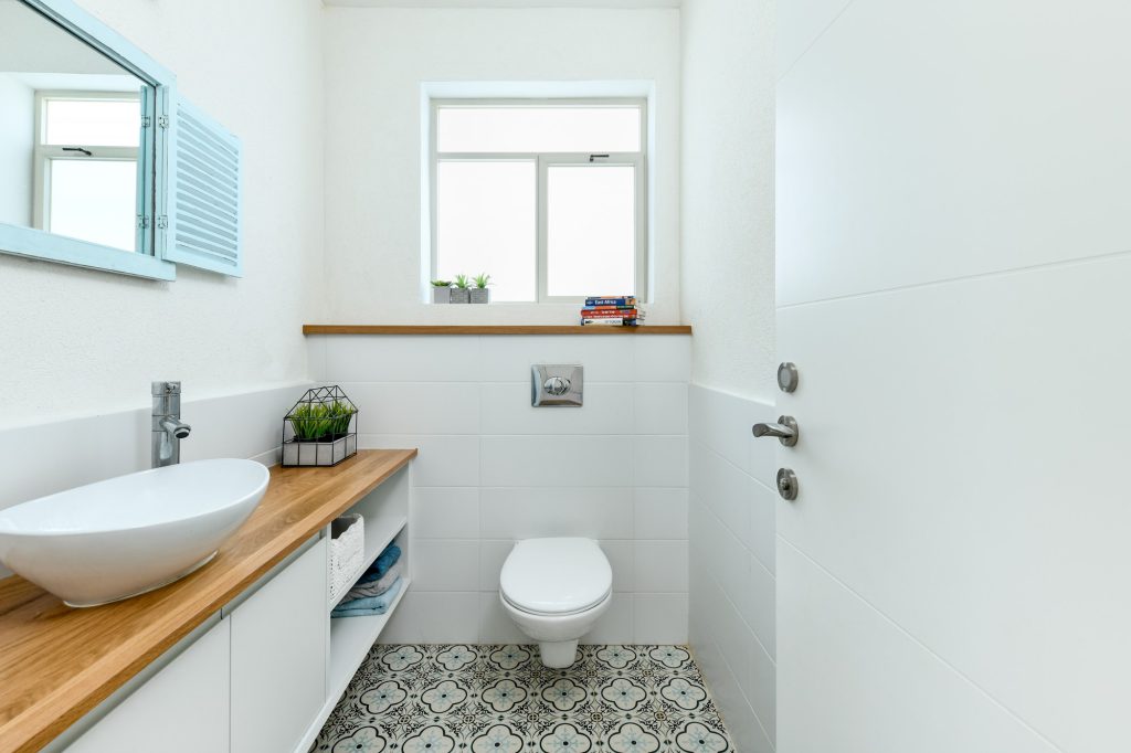 Bathroom with a wooden counter and a patterned tile floor