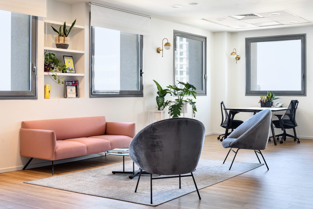 Pink sofa and grey armchairs by the windows