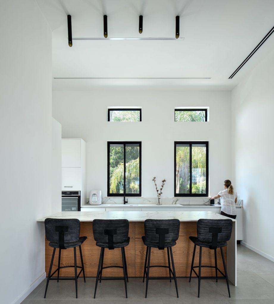White kitchen with a wooden island and black bar stools
