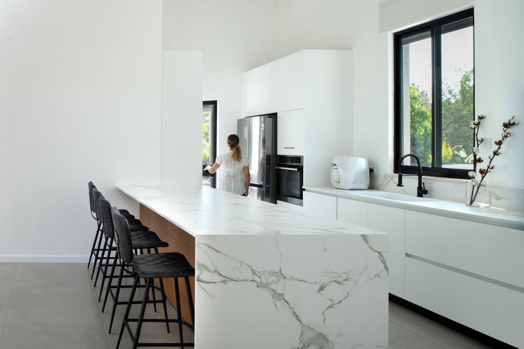 Marble-look kitchen island facing a garden window