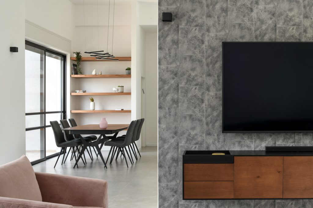 Grey stone-clad TV wall and pink armchairs