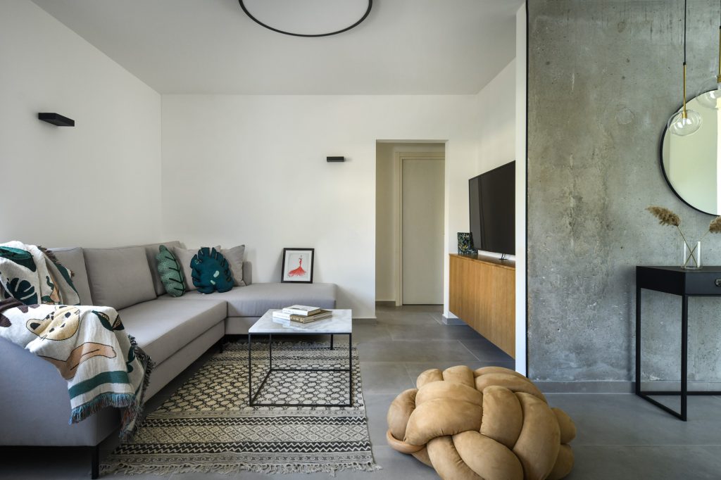 Living room with a grey corner sofa and a knot pouf