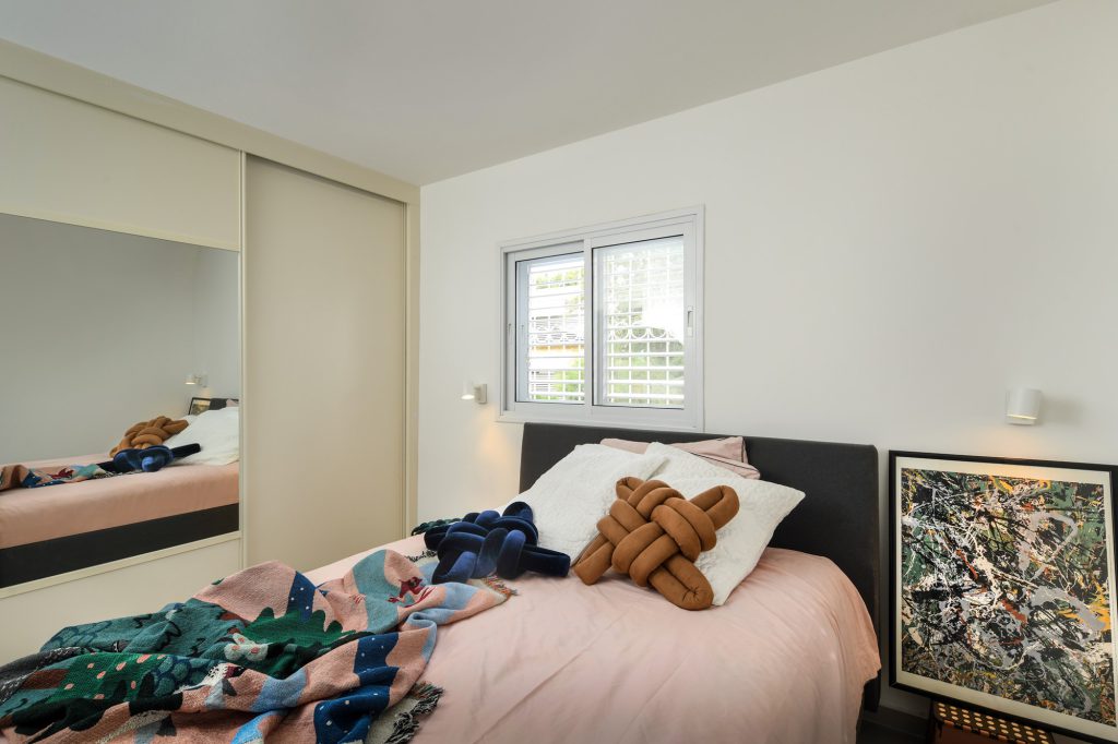 Bedroom with a sliding wardrobe and an artwork