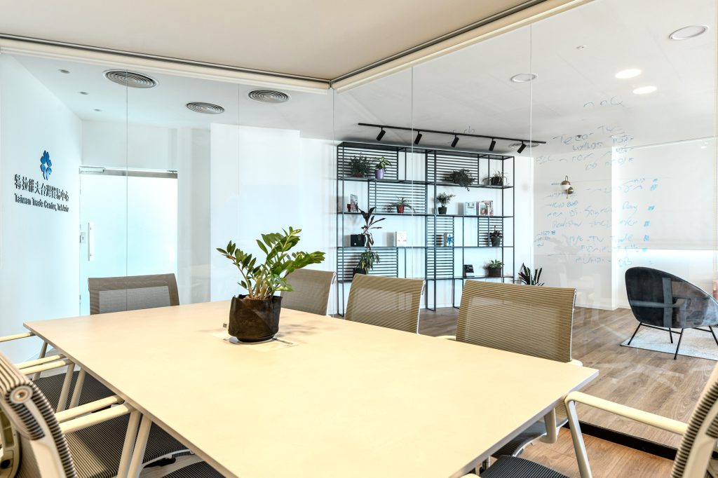 Meeting room with a white table, looking to the metal shelving