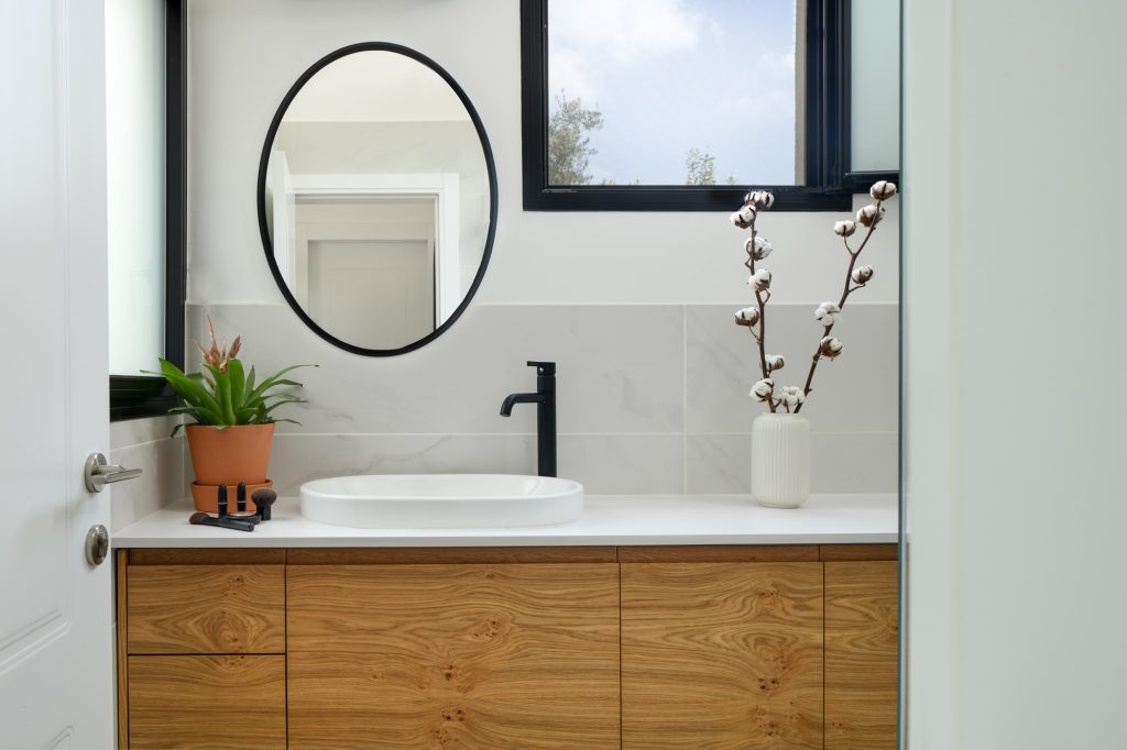 Wooden vanity and a black oval mirror