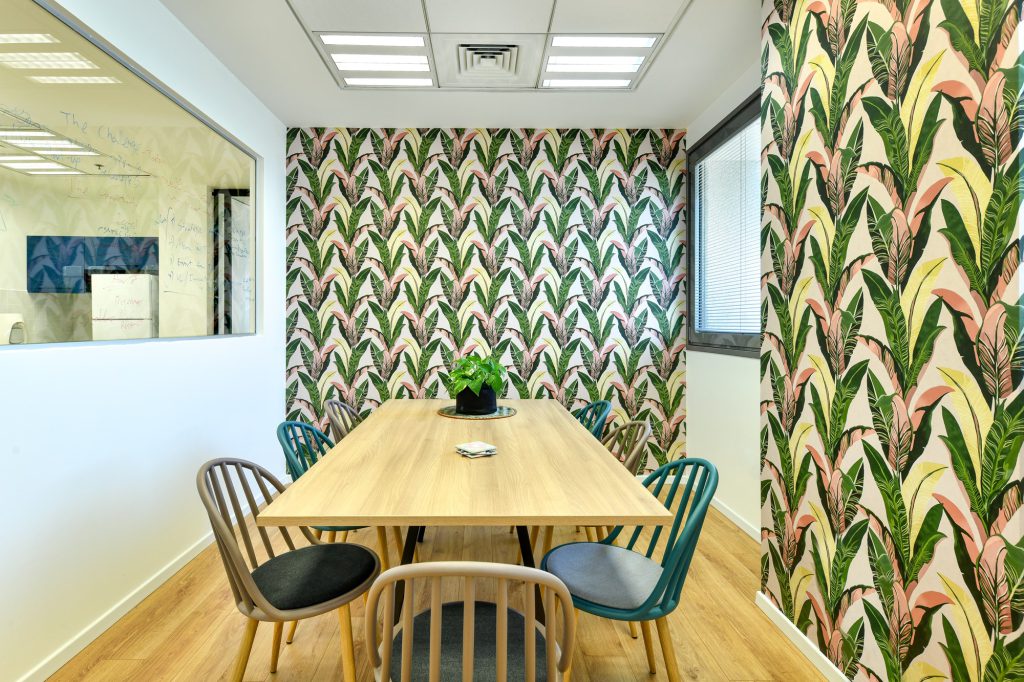 Meeting room with tropical wallpaper and wooden chairs