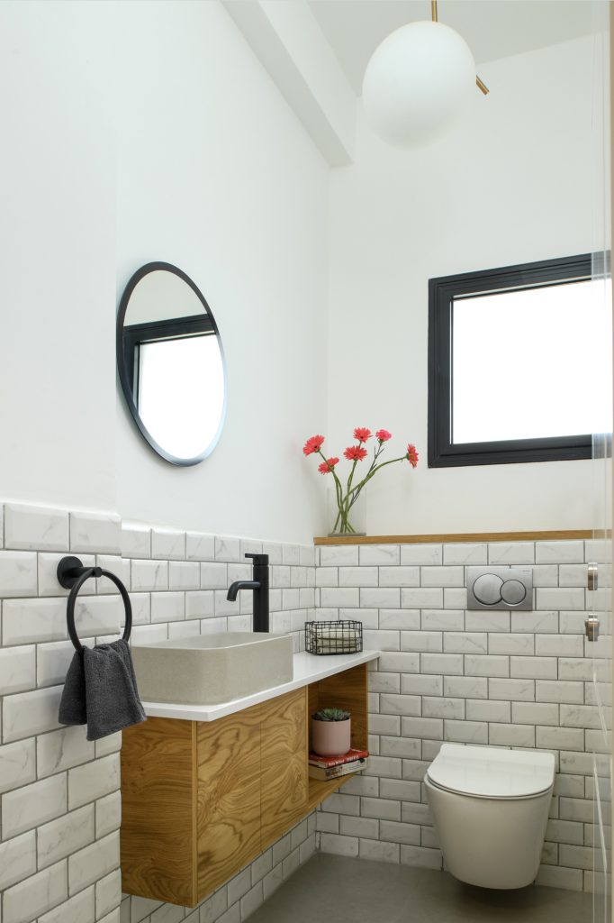 Guest toilet with subway tiles and a wall-hung wooden cabinet