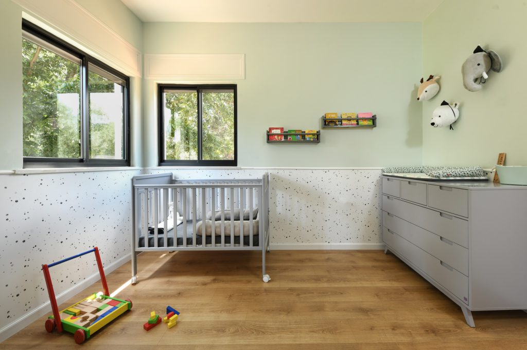 Nursery with a mint wall and a grey cot