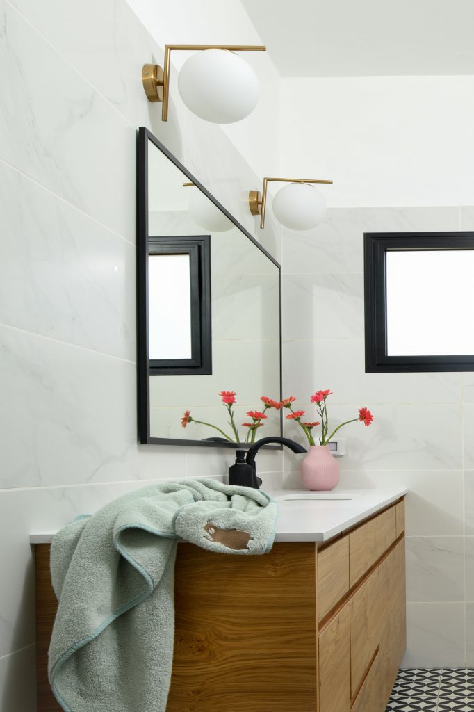 Wooden vanity and mirror with a brass wall light